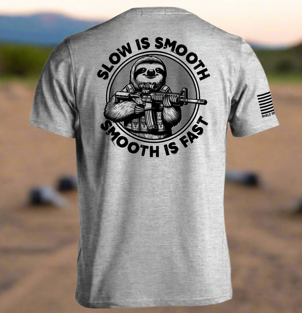 Gray t-shirt with a graphic of a sloth holding a rifle and text 'Slow is Smooth, Smooth is Fast' on the back.