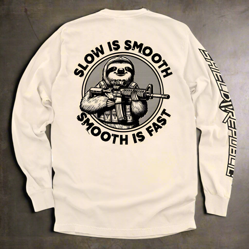 Long-sleeve shirt with a sloth holding a rifle graphic and text 'Slow is Smooth, Smooth is Fast' on a beige background.