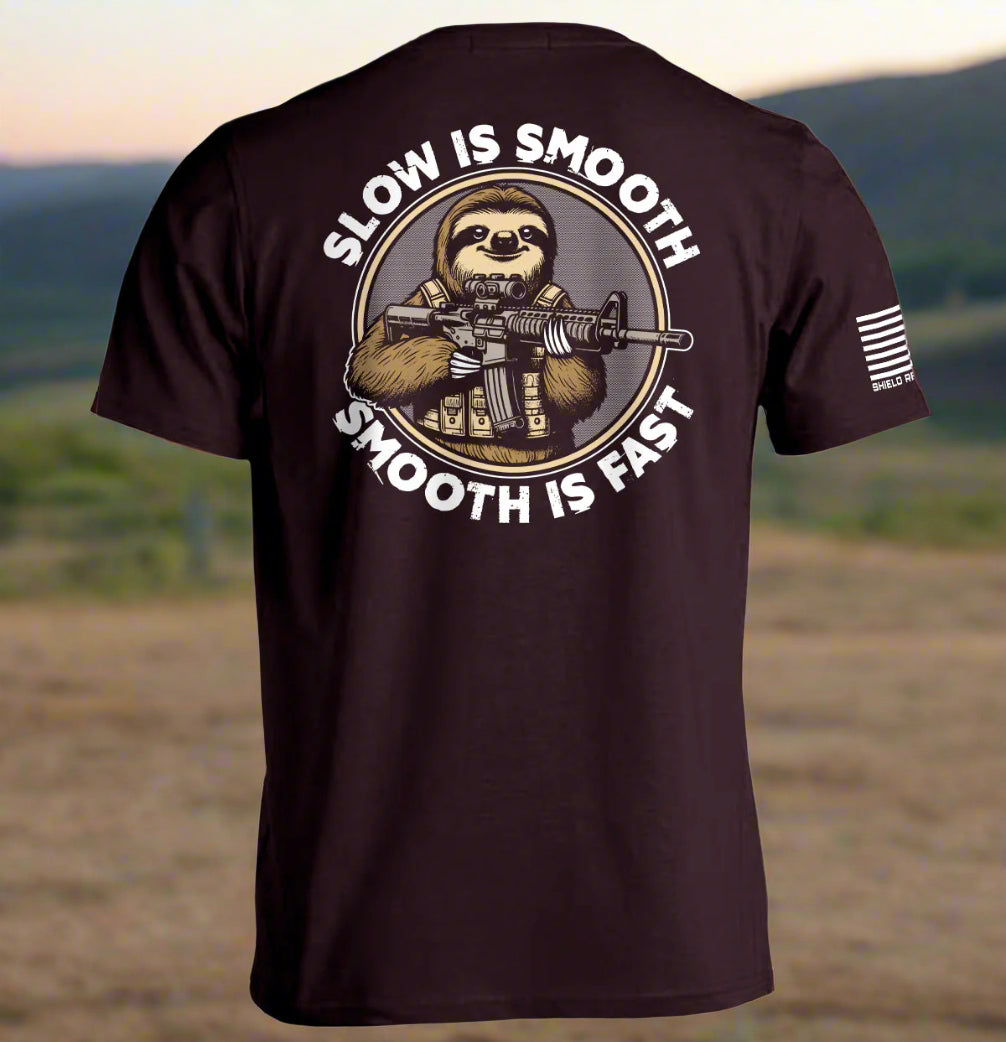 Oxblood colored t-shirt with a graphic of a sloth holding a rifle and text 'Slow is Smooth, Smooth is Fast' on the back.
