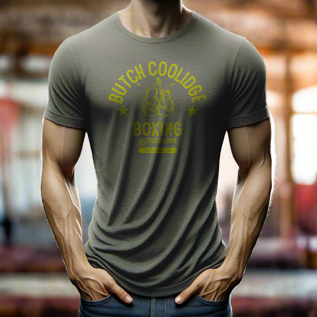 man wearing a t-shirt in a rustic old steamy boxing gym at magic hour