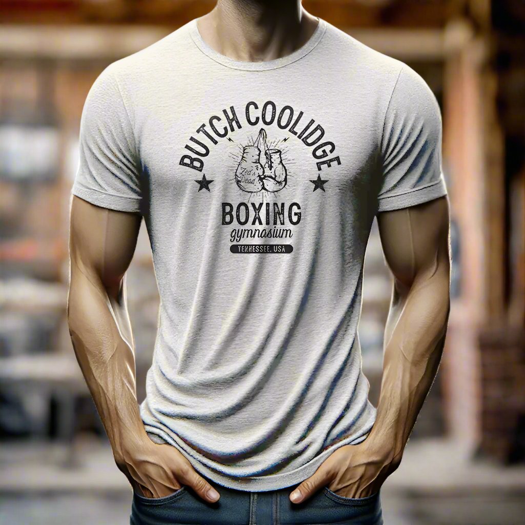 man wearing a t-shirt in a rustic old steamy boxing gym at magic hour