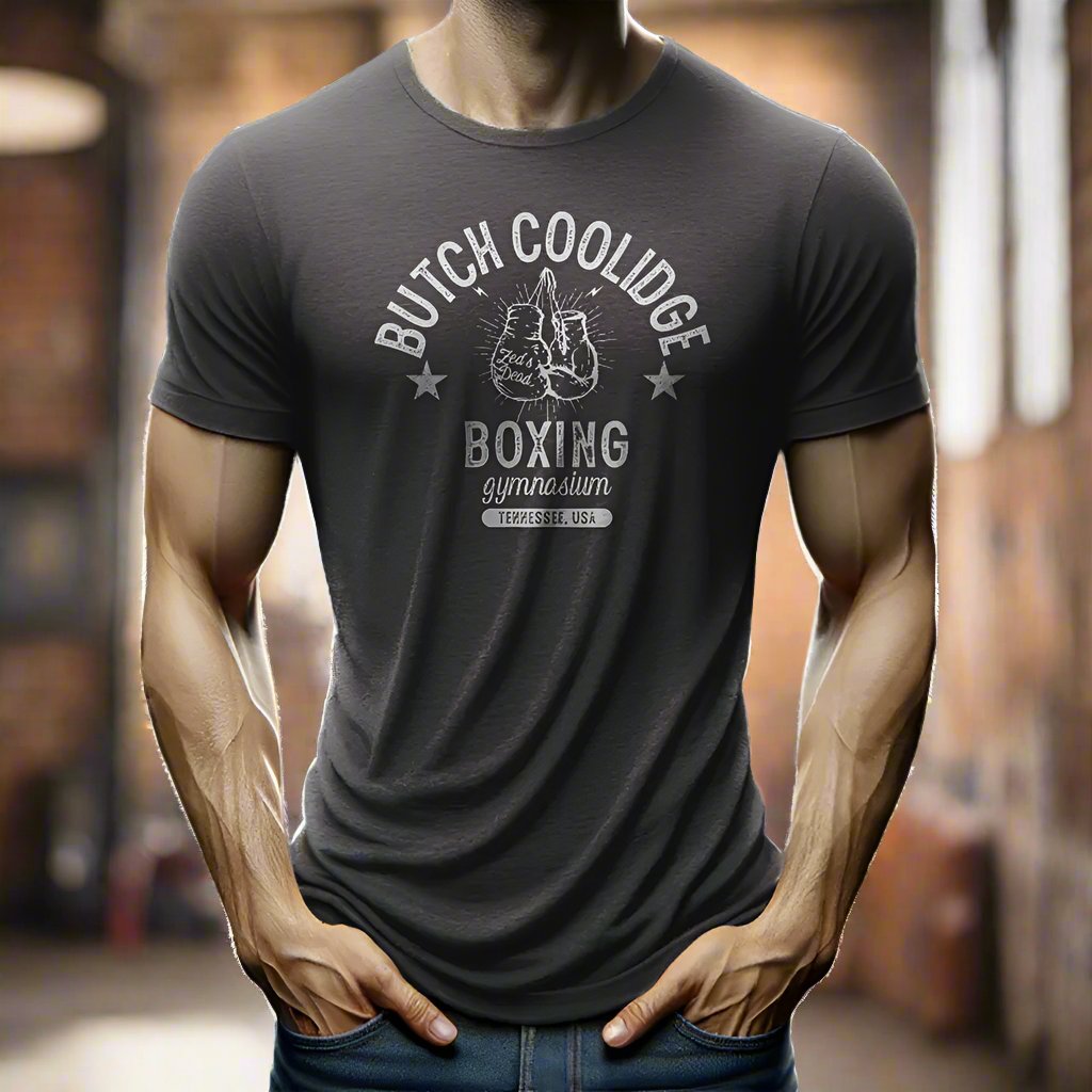 man wearing a t-shirt in a rustic old steamy boxing gym at magic hour