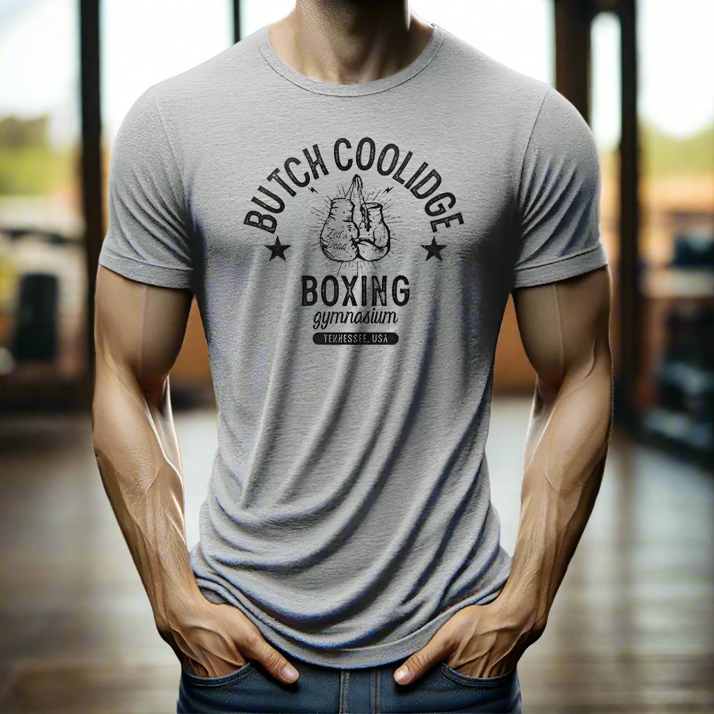 man wearing a t-shirt in a rustic old steamy boxing gym at magic hour