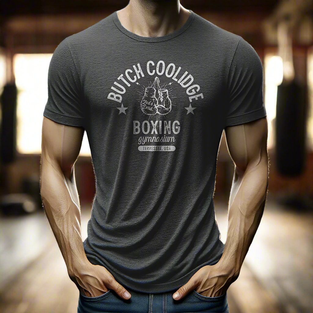 man wearing a t-shirt in a rustic old steamy boxing gym at magic hour