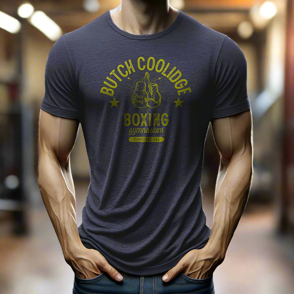 man wearing a t-shirt in a rustic old steamy boxing gym at magic hour